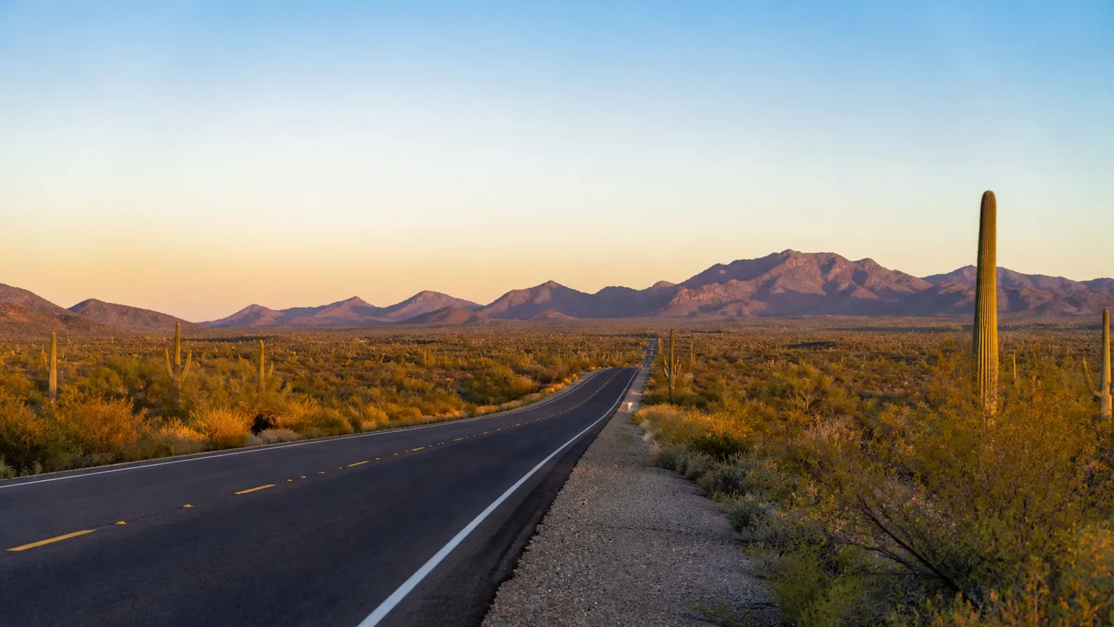 Open Arizona desert highway with distant mountains under a wide sky